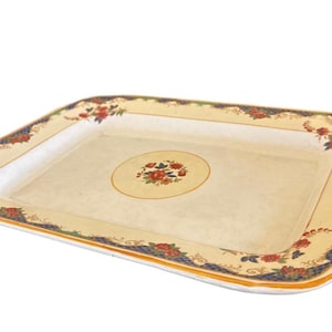 May include: A rectangular serving tray with a cream-colored center featuring a small floral medallion. The wide border displays a repeating pattern of red roses, green leaves, and blue lattice accents against a pale yellow background.