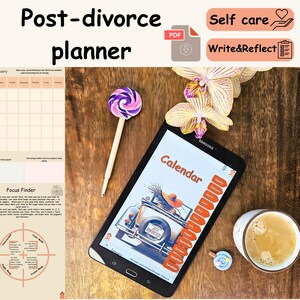 Op de afbeelding: Een post-scheidingsplanner met de tekst "Post-divorce planner" en "Calendar". De afbeelding bevat een tablet met een kalenderontwerp, een lolly, een kopje koffie en een bloem. De planner is ontworpen om te helpen met zelfzorg en reflectie.