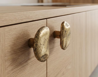 Conjunto de 2 puxadores de latão maciço com textura orgânica para armários de cozinha modernos.