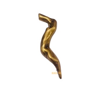 Può includere: Una maniglia decorativa curva color bronzo con una superficie strutturata. La maniglia ha una forma organica unica, con una parte superiore cilindrica e una parte inferiore affusolata. La maniglia è posta su uno sfondo bianco.