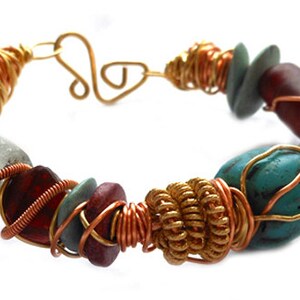Pode incluir: Uma pulseira artesanal com uma variedade de contas coloridas. A pulseira incorpora pedras turquesa, vermelhas e cinza-esverdeadas, acentuadas com arame de cobre e dourado. O fecho &eacute; um design simples de gancho e argola.