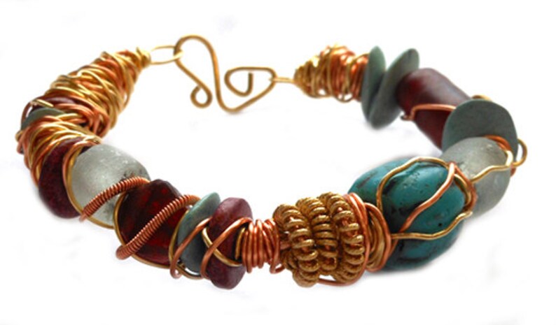 Pode incluir: Uma pulseira artesanal com uma variedade de contas coloridas. A pulseira incorpora pedras turquesa, vermelhas e cinza-esverdeadas, acentuadas com arame de cobre e dourado. O fecho &eacute; um design simples de gancho e argola.