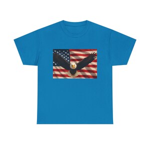 May include: A turquoise t-shirt with a graphic of the American flag and a bald eagle in flight. The eagle has a white head and a yellow beak, with its wings spread wide against the backdrop of the flag.