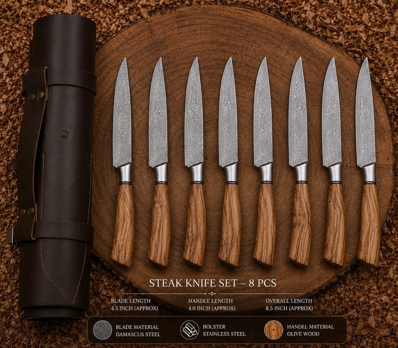 Peut inclure: Un ensemble de huit couteaux &agrave; steak avec des lames en acier Damas et des manches en bois d'olivier, accompagn&eacute;s d'un &eacute;tui en cuir marron fonc&eacute;. Le texte indique : STEAK KNIFE SET - 8 PCS, BLADE LENGTH 11,43 CM, HANDLE LENGTH 10,16 CM, OVERALL LENGTH 21,59 CM.