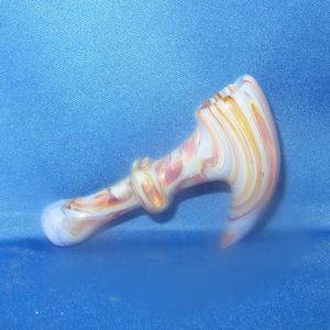 May include: A glass pipe with a white, pink, and orange swirl design. The pipe is shaped like a hammer.