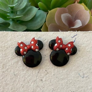 Puede incluir: Dos adornos negros con forma de Minnie Mouse con lazos rojos brillantes y lunares blancos. Los adornos tienen un acabado brillante. Ideales para manualidades y proyectos de bricolaje.