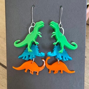 Cascade of Dinosaur Earrings.  Laser Cut Acrylic.  Shop Name: Jillmccp. JMP Designs