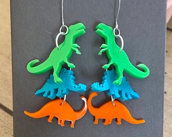 Cascade of Dinosaur Earrings.  Laser Cut Acrylic.  Shop Name: Jillmccp. JMP Designs