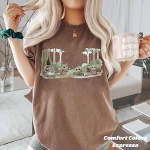 Puede incluir: Camiseta color espresso con un gr&aacute;fico de un personaje de una popular serie de ciencia ficci&oacute;n. El dise&ntilde;o muestra varios personajes en un entorno forestal. Las palabras "Comfort Colors" y "Espresso" est&aacute;n impresas en la parte inferior de la camiseta.