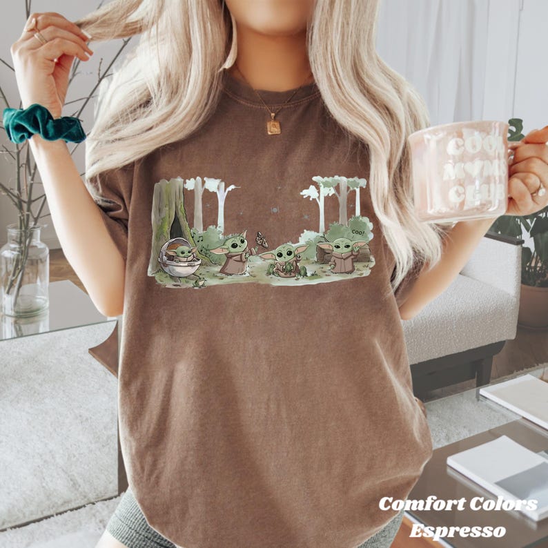 Puede incluir: Camiseta color espresso con un gr&aacute;fico de un personaje de una popular serie de ciencia ficci&oacute;n. El dise&ntilde;o muestra varios personajes en un entorno forestal. Las palabras "Comfort Colors" y "Espresso" est&aacute;n impresas en la parte inferior de la camiseta.