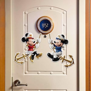 May include: Two decorative wall decals featuring cartoon mice dressed in nautical uniforms, each holding a rope attached to a gold anchor. One mouse wears a red jacket and white skirt, the other a blue jacket and white pants. Both anchors feature the word NAME.