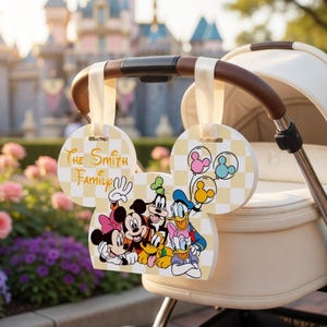 May include: A stroller tag in the shape of Mickey Mouse's head, displaying "The Smith Family" and Disney characters. The tag has a yellow and white checkered pattern and is attached to a stroller.