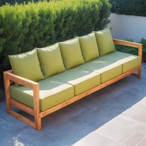 May include: A wooden outdoor sofa with four green cushions. The sofa is made of natural wood and has a simple, modern design.