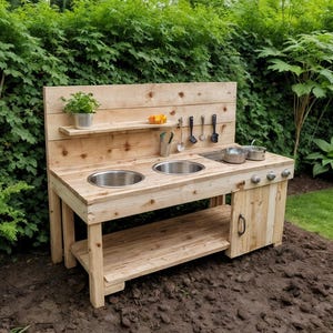 May include: A wooden outdoor play kitchen with two stainless steel sinks, a shelf, and a lower storage area. The play kitchen has a wooden backsplash with a shelf holding a potted plant and some toy fruit. The play kitchen is set in a garden.