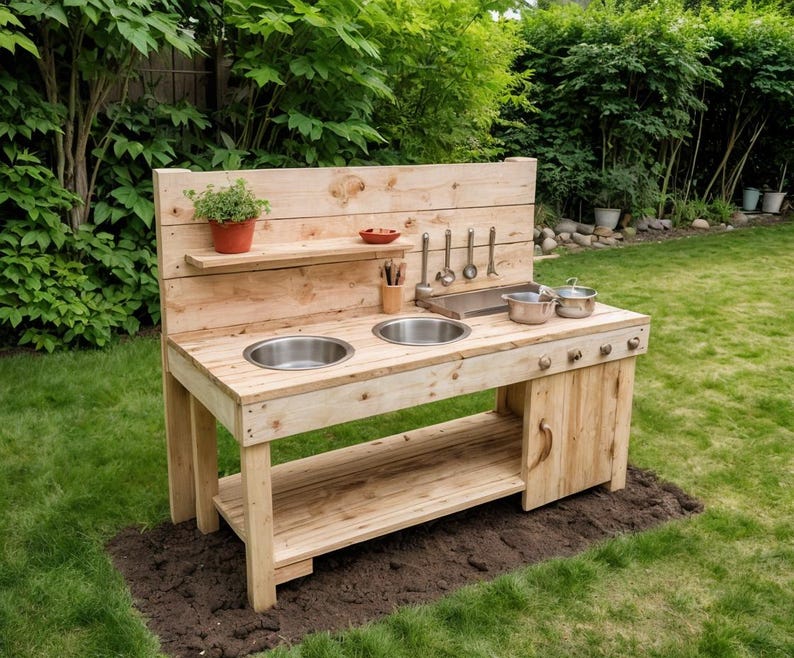 May include: A wooden outdoor play kitchen with two stainless steel sinks, a shelf, and a backsplash. It includes pots, utensils, and a small plant. The play kitchen is set on a patch of dirt in a grassy backyard.