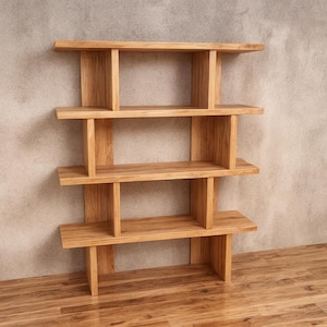 May include: A light brown wooden bookshelf with four shelves. The shelves are supported by vertical wooden beams. The bookshelf is made of solid wood and has a natural finish. The bookshelf is designed to stand against a wall.