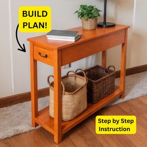 May include: A wooden console table with a drawer, a lower shelf, and two baskets. The table is stained a warm orange colour. The text "BUILD PLAN!" and "Step by Step Instruction" are in the image.