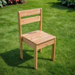 May include: A wooden chair with a slatted seat and back, constructed from light-colored wood. The chair is positioned on a green lawn, with the sun casting a shadow. The chair's design is simple and classic, suitable for outdoor use.