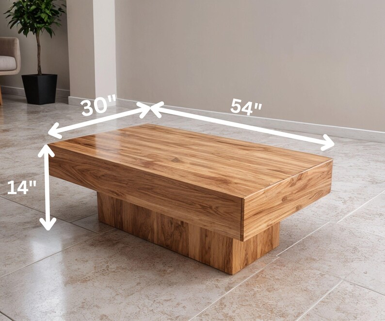 May include: A rectangular wooden coffee table with a natural wood grain finish. The table is 137 cm long, 76 cm wide, and 36 cm high. The table has a solid base and a simple, modern design.