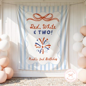 May include: A rectangular fabric backdrop featuring light blue vertical stripes and a central white panel with a scalloped border. The text reads Red, White & TWO! and Noah's 2nd Birthday in red and blue, with a red and blue firework graphic.