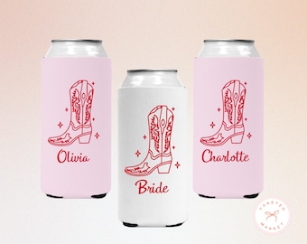 May include: Three beverage can coolers featuring a red line art graphic of a cowboy boot surrounded by small stars. The two outer coolers are light pink with the names Olivia and Charlotte, while the center cooler is white with the word Bride.