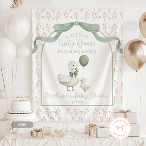 Pu&ograve; includere: Un fondale per baby shower con un'illustrazione di un'oca e un'ochetta, un fiocco verde e la scritta "A Little Silly Goose Is Almost Loose!". Lo sfondo presenta un motivo floreale e include la scritta "Madison's Baby Shower" e la data 4.18.26.