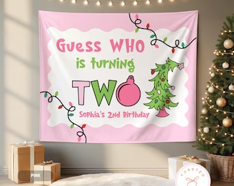 May include: A pink birthday banner with the text "Guess WHO is turning TWO" in pink and green. The banner includes a Christmas tree and ornament graphic. The text "Sophia's 2nd Birthday" is also included. The banner is decorated with string lights.