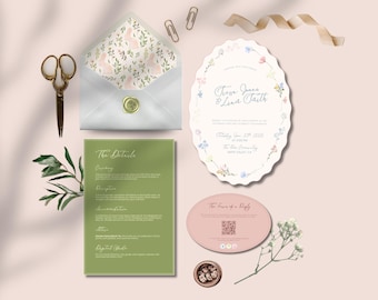 May include: A flat lay of wedding stationery, including an invitation with floral accents, a details card, and a reply card. The invitation features the names "Trevor Jones & Luna Faith". A white envelope with a bunny pattern is sealed with a gold wax stamp.