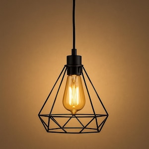 May include: Black geometric pendant light with a warm, glowing Edison bulb. The light fixture has a diamond-shaped cage design and a black cord. The bulb is a classic teardrop shape, emitting a soft, inviting light.