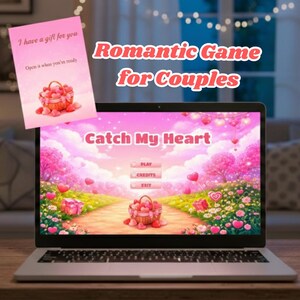 Puede incluir: Una computadora portátil muestra un juego romántico llamado "Catch My Heart". Una tarjeta rosa dice "Tengo un regalo para ti" y "Ábrelo cuando estés listo". El juego se anuncia como un "Juego romántico para parejas".