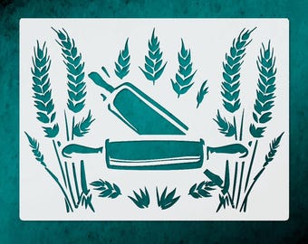 May include: A white stencil featuring a rolling pin and wheat stalks in a teal color. The rolling pin is positioned horizontally, with wheat stalks and leaves arranged around it. The design is set against a teal background.
