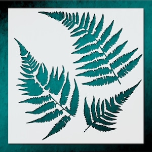 May include: A stencil featuring four fern leaf designs in a teal color. The fern leaves are arranged on a white background, with a dark teal border. The leaves have detailed, intricate cut-out patterns.