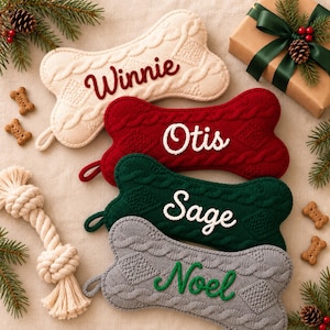 May include: Four bone-shaped knit stockings with cable patterns. The cream stocking features the name Winnie in red, the red stocking features Otis in white, the green stocking features Sage in white, and the gray stocking features Noel in green.