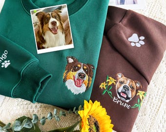 May include: Two sweatshirts, one green and one brown, with dog-themed embroidery. The green sweatshirt features a dog portrait and a paw print on the sleeve. The brown sweatshirt has a dog portrait with the name "Bruno" embroidered below.