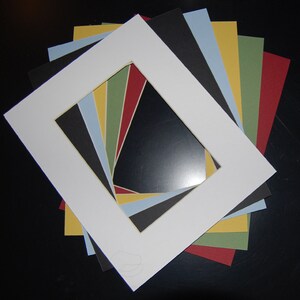 Puede incluir: Un conjunto de ocho cartulinas blancas con diferentes colores de cartulinas interiores. Las cartulinas interiores son negras, rojas, amarillas, verdes y azules.