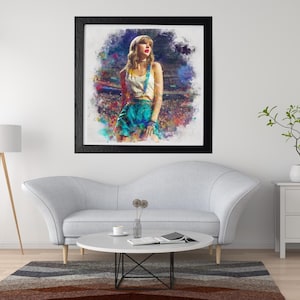 May include: Framed art print featuring a watercolor-style portrait of a woman in a white top and teal skirt with suspenders. The artwork is set against a colorful, abstract background and framed in black. The print is displayed above a gray sofa.