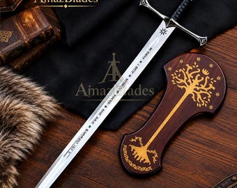 May include: A silver-toned metal sword with a black leather-wrapped grip, a cross-guard, and a pommel. The blade features engraved runic text and a star symbol. Beside the sword lies a dark wooden plaque decorated with a gold-colored tree design.