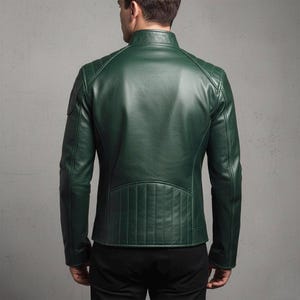 Deep green genuine leather biker jacket for men, featuring asymmetrical zip, stand-up collar with buckle, quilted shoulder panels, zippered cuffs, functional pockets, and embroidered wing patch – stylish and handcrafted motorcycle outerwear.