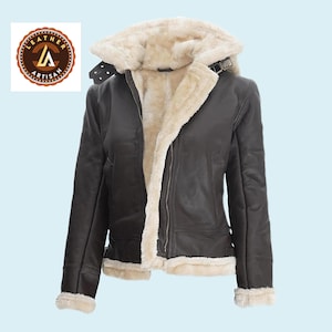 Puede incluir: Chaqueta de cuero marrón oscuro con forro y capucha de borrego color crema. La chaqueta tiene cierre de cremallera, cuello abrochado y ribete de borrego en los puños y el dobladillo. Estilo aviador clásico.