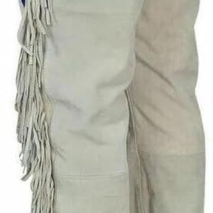 May include: Tan suede pants with decorative fringe along the side. The pants have a belt and a decorative beaded pattern in blue and white. These pants are a Western wear style.