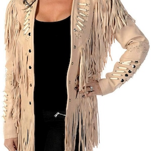 May include: A light beige suede jacket with long fringe and decorative bone-like accents. The jacket has a button closure and long sleeves.
