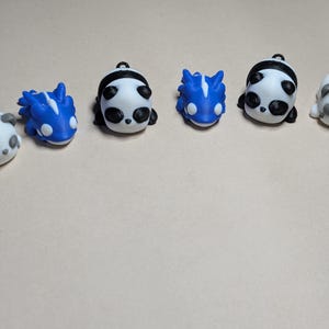 May include: A set of three ceramic mugs with a speckled, matte finish in cream, light grey, and dark grey. Each mug has a simple, minimalist design and a rounded handle.