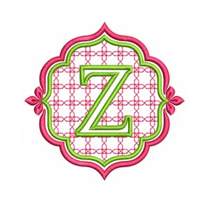 May include: An embroidery design featuring a lime green letter Z centred within a pink and lime green quatrefoil frame. The background inside the frame consists of a pink geometric lattice pattern on a white field, with pink accents.