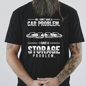 May include: Black t-shirt with the text "NO, I DON'T HAVE A CAR PROBLEM. I HAVE A STORAGE PROBLEM." Four classic car illustrations are above the text "I HAVE A".