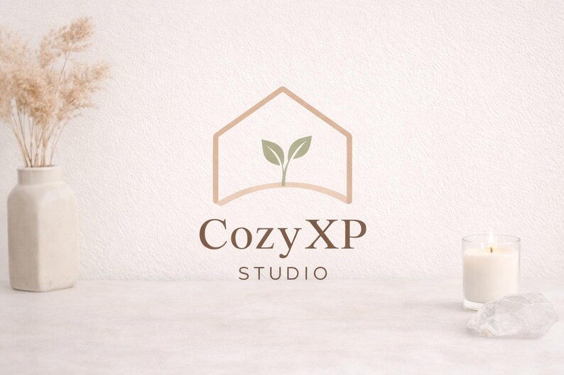 K&ouml;nnte beinhalten: Minimalistisches Logo f&uuml;r Cozy XP Studio, mit einer Hausumriss mit Bl&auml;ttern im Inneren. Das Logo ist in Braunt&ouml;nen gehalten, mit dem Text "Cozy XP STUDIO" darunter. Eine Vase mit getrockneten Pflanzen, eine brennende Kerze und ein Kristall sind ebenfalls im Bild.
