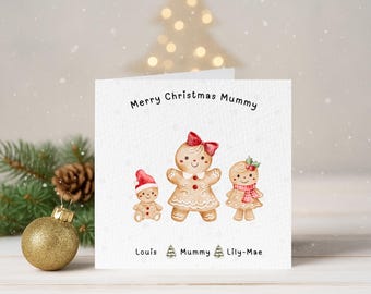 May include: A Christmas card with a watercolor illustration of gingerbread people. The card reads "Merry Christmas Mummy" and features three gingerbread figures, each with unique accessories. The card is decorated with snowflakes and a gold ornament.