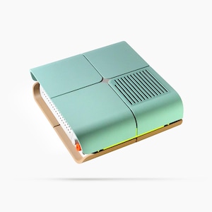 May include: A modern, mint green and tan electronic device with a unique design. The device has a rectangular shape with a curved top and a vent on one side. The base is tan, and the top is divided into four sections.