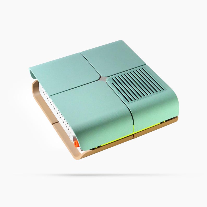 May include: A modern, mint green and tan electronic device with a unique design. The device has a rectangular shape with a curved top and a vent on one side. The base is tan, and the top is divided into four sections.