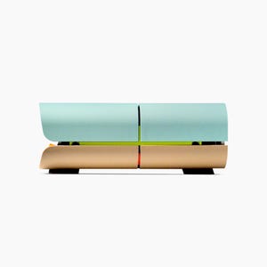 May include: A modern, two-tiered, modular storage unit. The top section is a light teal color, and the bottom section is a warm gold. A thin, neon green line separates the two sections. The unit is on black feet.