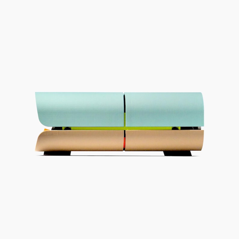 May include: A modern, two-tiered, modular storage unit. The top section is a light teal color, and the bottom section is a warm gold. A thin, neon green line separates the two sections. The unit is on black feet.